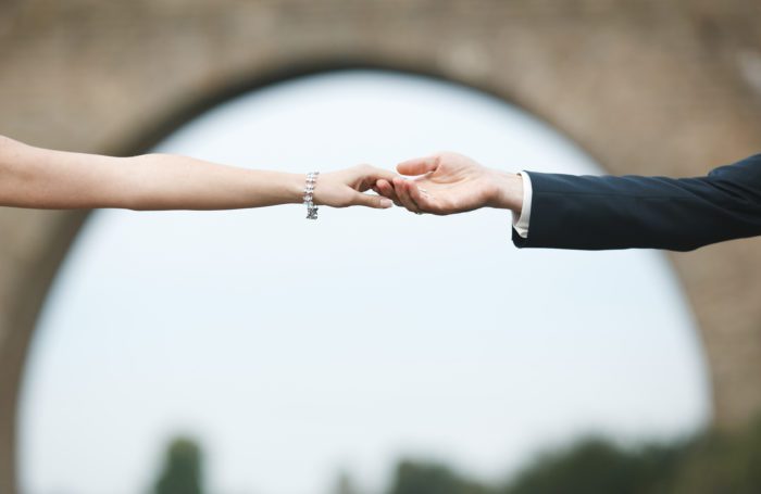 high net worth couple holding hands after signing prenuptial agreement